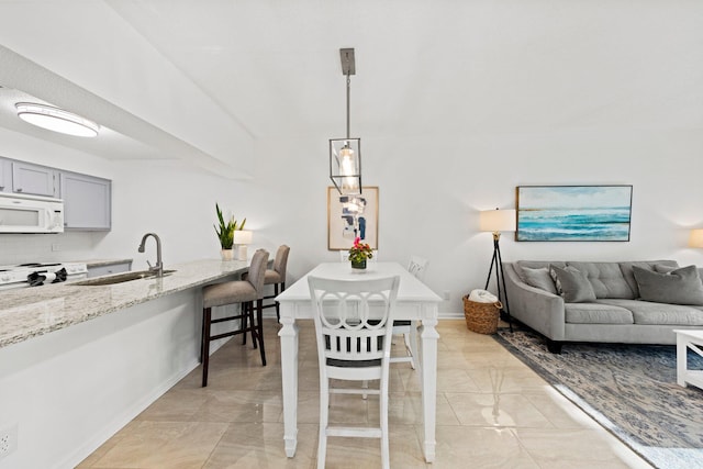 dining area featuring sink and light tile floors