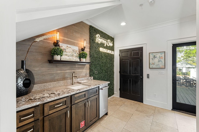 interior space featuring light stone counters, light tile floors, sink, dark brown cabinets, and ornamental molding