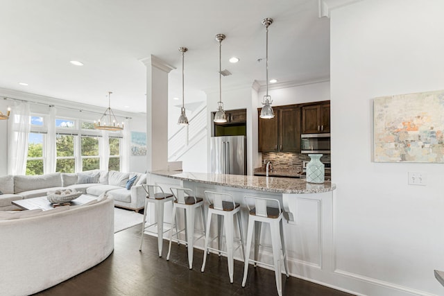 kitchen with tasteful backsplash, stainless steel appliances, dark hardwood / wood-style flooring, and decorative light fixtures