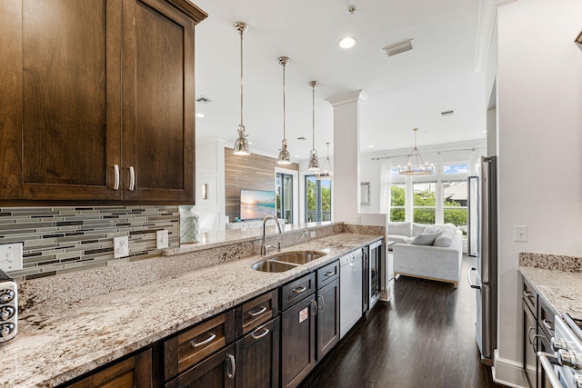 kitchen featuring sink, backsplash, decorative light fixtures, stainless steel fridge, and dark hardwood / wood-style floors