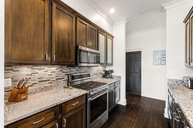 kitchen featuring backsplash, dark hardwood / wood-style floors, stainless steel appliances, and light stone counters