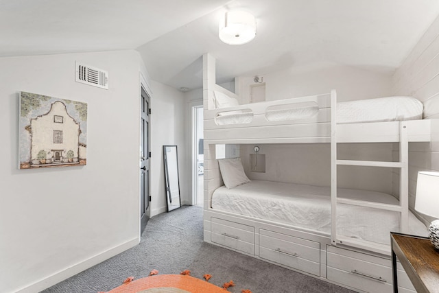 bedroom with dark colored carpet and lofted ceiling