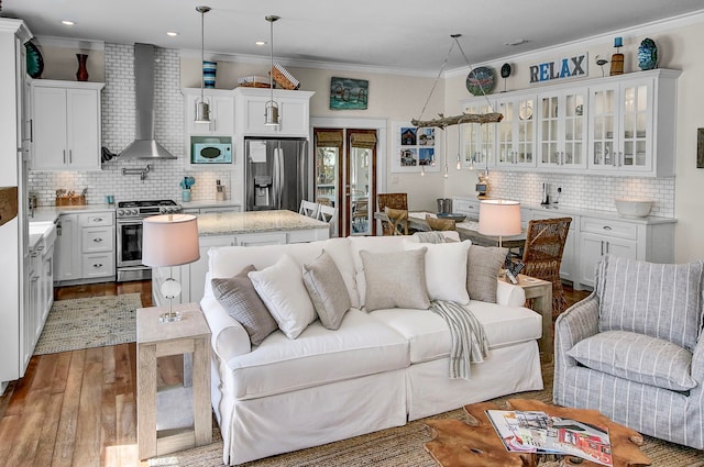 living room with ornamental molding, sink, french doors, and light wood-type flooring