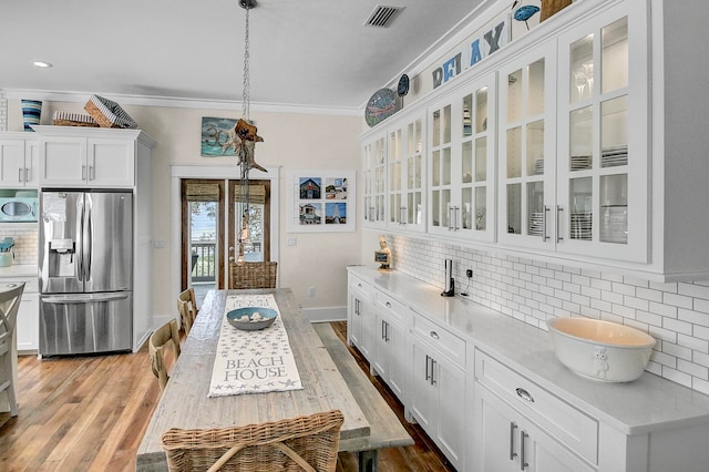 kitchen with backsplash, light hardwood / wood-style flooring, and stainless steel fridge with ice dispenser