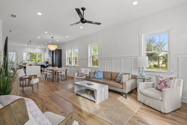 living room featuring ceiling fan and light wood-type flooring