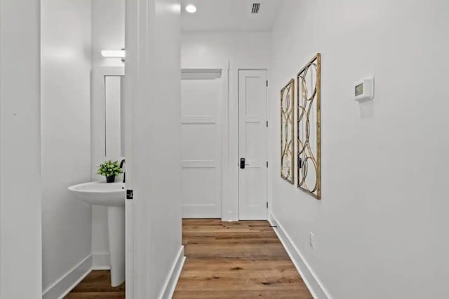 corridor with hardwood / wood-style flooring