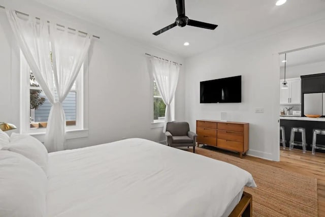 bedroom with refrigerator, light hardwood / wood-style floors, and ceiling fan