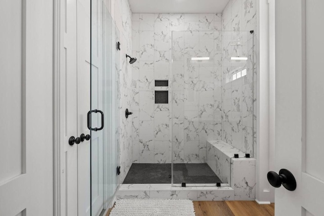 bathroom featuring hardwood / wood-style flooring and a shower with shower door