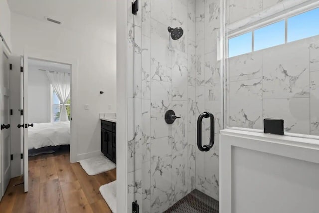 bathroom featuring hardwood / wood-style flooring and a shower with shower door