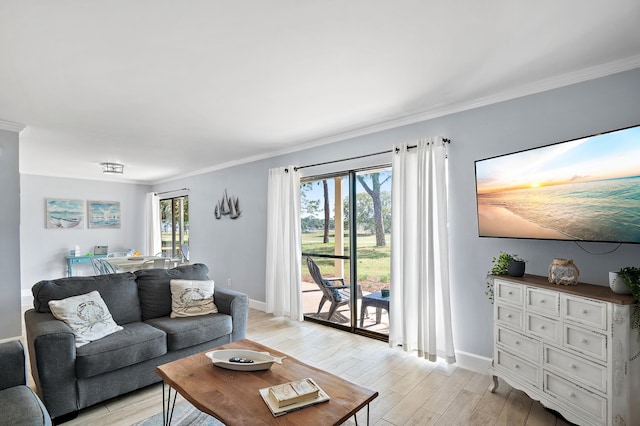 living room with a healthy amount of sunlight, crown molding, and light wood-type flooring