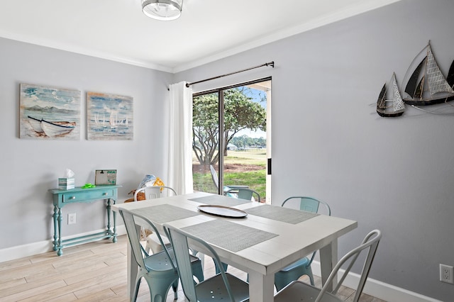 dining area featuring ornamental molding and light hardwood / wood-style flooring