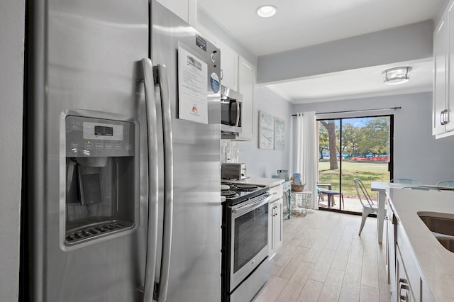 kitchen featuring light hardwood / wood-style floors, white cabinets, and stainless steel appliances