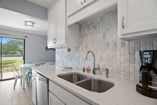 kitchen with white cabinetry, sink, backsplash, and stainless steel dishwasher