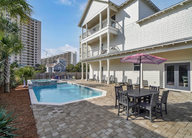 view of pool featuring a patio, french doors, and an in ground hot tub