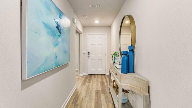 corridor with light hardwood / wood-style floors