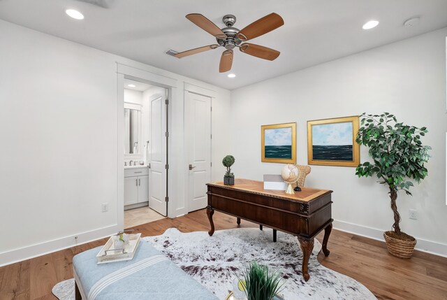 office space featuring ceiling fan, sink, and light hardwood / wood-style floors