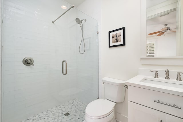 bathroom with vanity, ceiling fan, a shower with door, and toilet