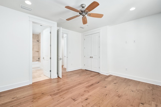 unfurnished bedroom featuring connected bathroom, light hardwood / wood-style floors, a closet, and ceiling fan