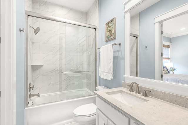 full bathroom featuring vanity, combined bath / shower with glass door, and toilet