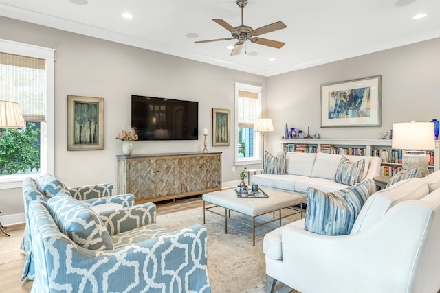 living room featuring light hardwood / wood-style floors, ornamental molding, and ceiling fan