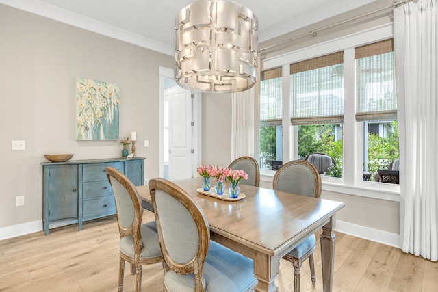 dining room featuring a notable chandelier, ornamental molding, and light hardwood / wood-style flooring