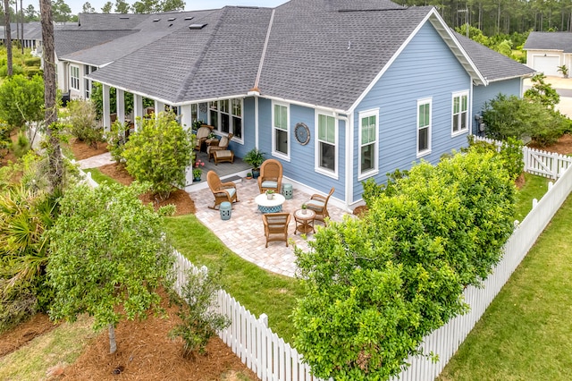 rear view of property with a patio, an outdoor fire pit, and a lawn