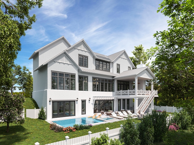 rear view of property featuring a balcony, a yard, and a fenced in pool