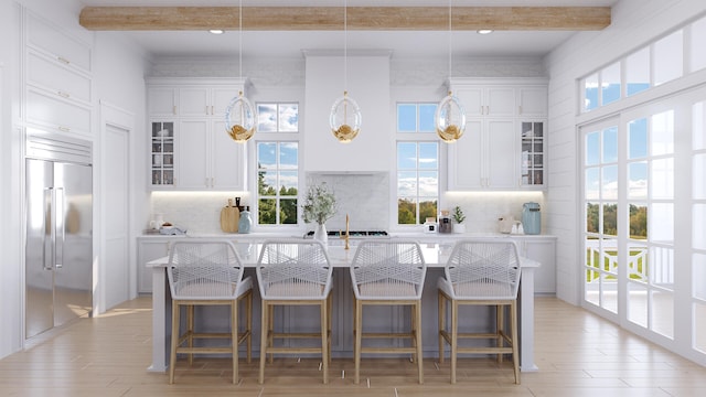 kitchen with decorative light fixtures, beam ceiling, and built in refrigerator