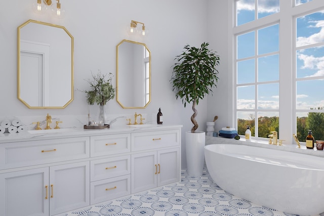 bathroom featuring a washtub, double sink vanity, tile floors, and a wealth of natural light