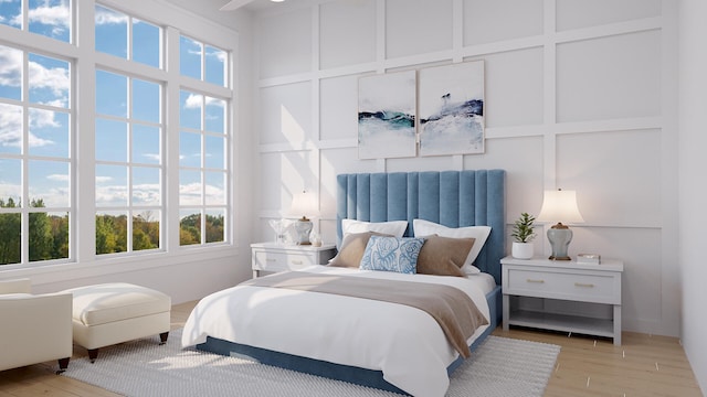 bedroom featuring a towering ceiling, light hardwood / wood-style floors, and ceiling fan