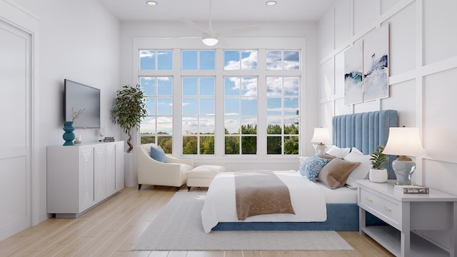 bedroom with light hardwood / wood-style flooring, ceiling fan, and multiple windows