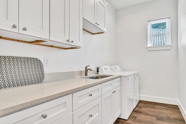 laundry area featuring dark wood-type flooring, cabinets, independent washer and dryer, and sink