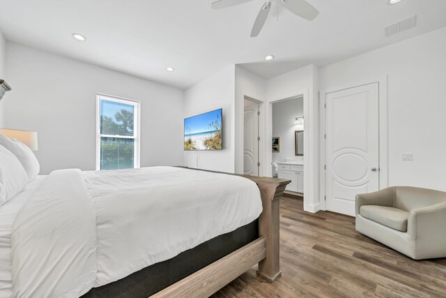 bedroom with connected bathroom, ceiling fan, and dark hardwood / wood-style floors