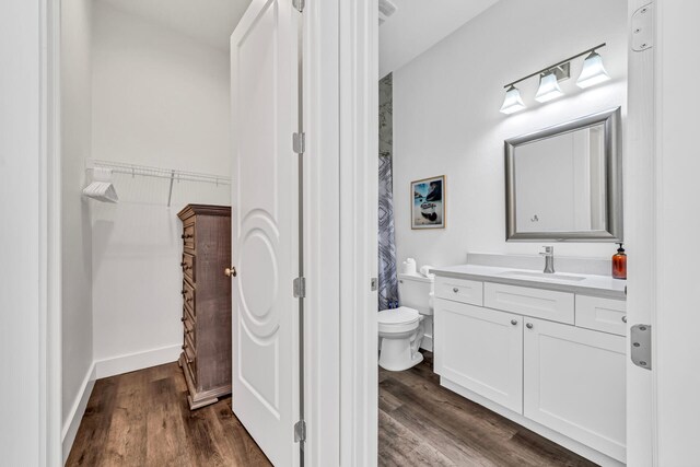 bathroom with vanity, toilet, and wood-type flooring