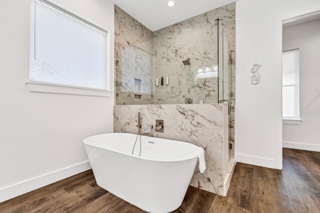 bathroom with tile walls, independent shower and bath, and wood-type flooring