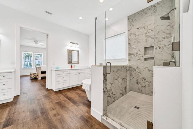 bathroom with ceiling fan, an enclosed shower, hardwood / wood-style flooring, and vanity