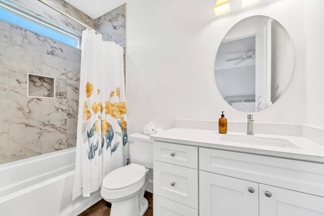 full bathroom featuring toilet, wood-type flooring, shower / tub combo, ceiling fan, and vanity