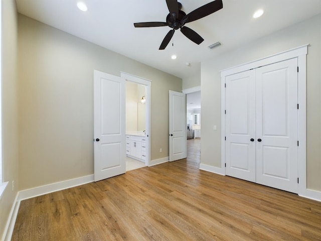 unfurnished bedroom featuring connected bathroom, ceiling fan, a closet, and light hardwood / wood-style floors