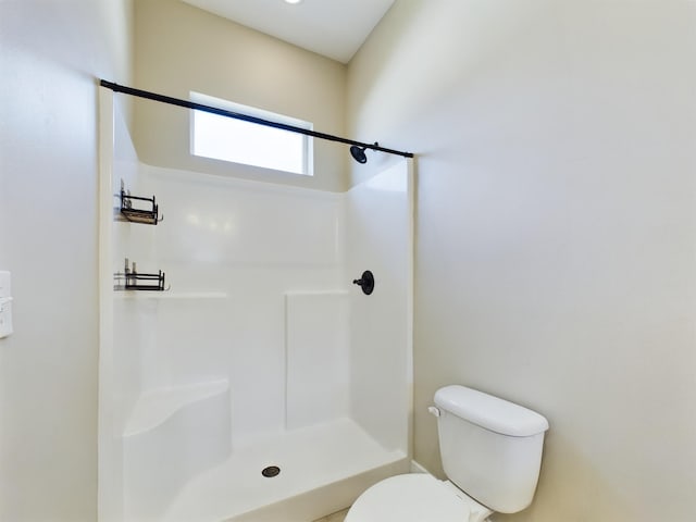 bathroom featuring toilet and walk in shower