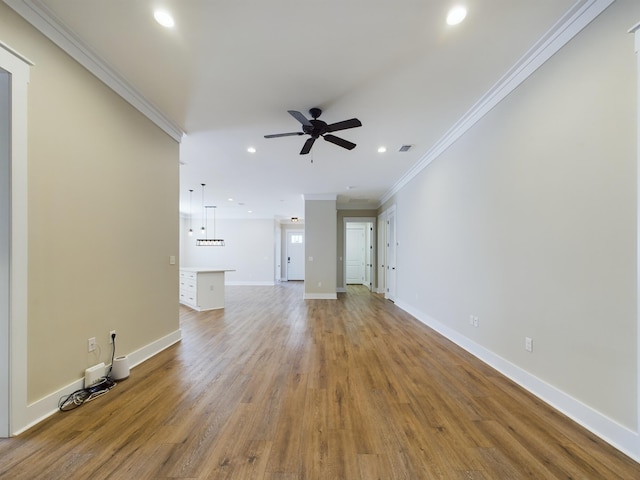 unfurnished living room with wood-type flooring, ceiling fan, and crown molding