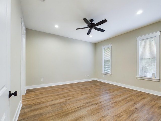 spare room featuring a wealth of natural light, light hardwood / wood-style flooring, and ceiling fan