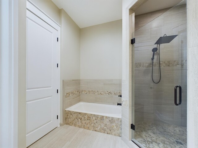 bathroom featuring independent shower and bath