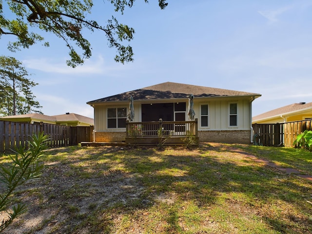 rear view of house with a lawn and a deck