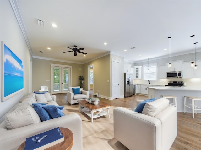 living room with french doors, light wood-type flooring, ceiling fan, and ornamental molding