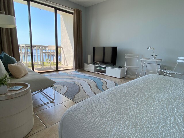 bedroom with access to outside and light tile floors