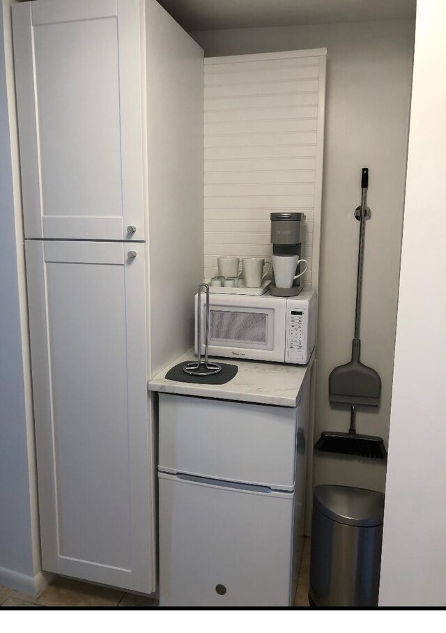 kitchen with tile flooring and white cabinets