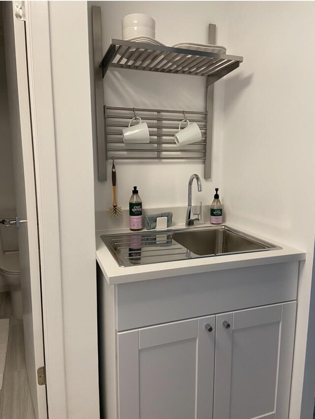 bar featuring sink and gray cabinetry