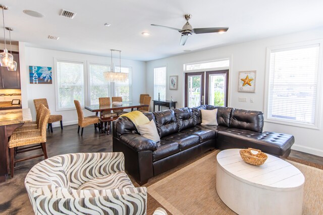 living room with french doors, a healthy amount of sunlight, and ceiling fan with notable chandelier