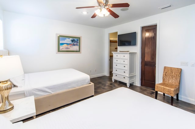 bedroom with dark hardwood / wood-style flooring and ceiling fan