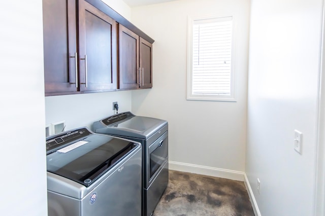 clothes washing area featuring cabinets and washer and dryer